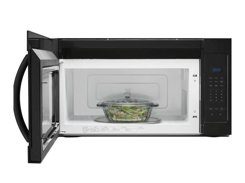 A glass container with meat and vegetables in a microwave A glass container with meat and vegetables in a microwave