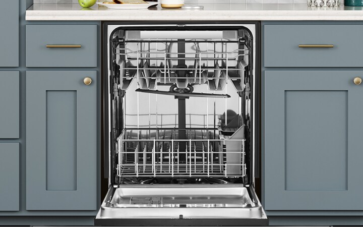 Open empty dishwasher among kitchen cabinets