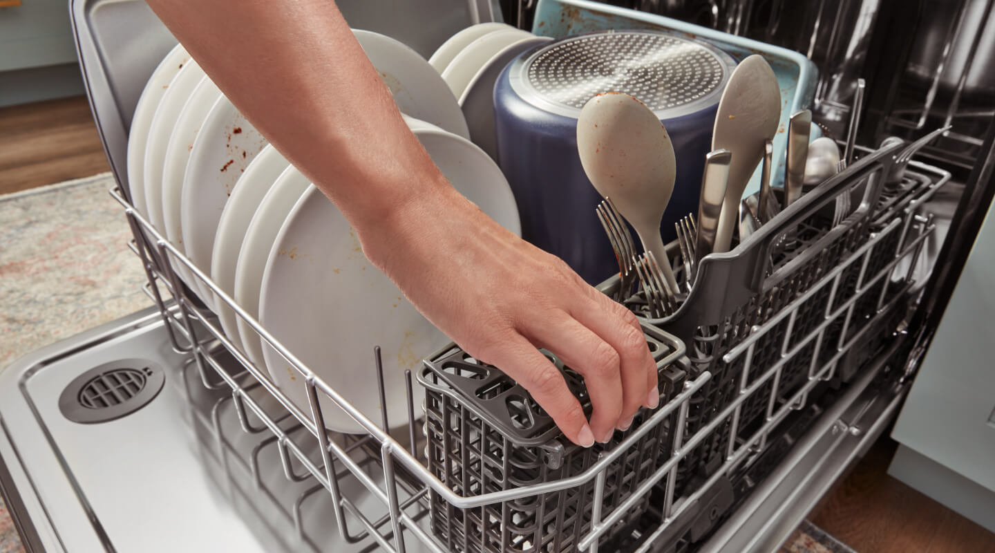 Person loading a dishwasher Person loading a dishwasher