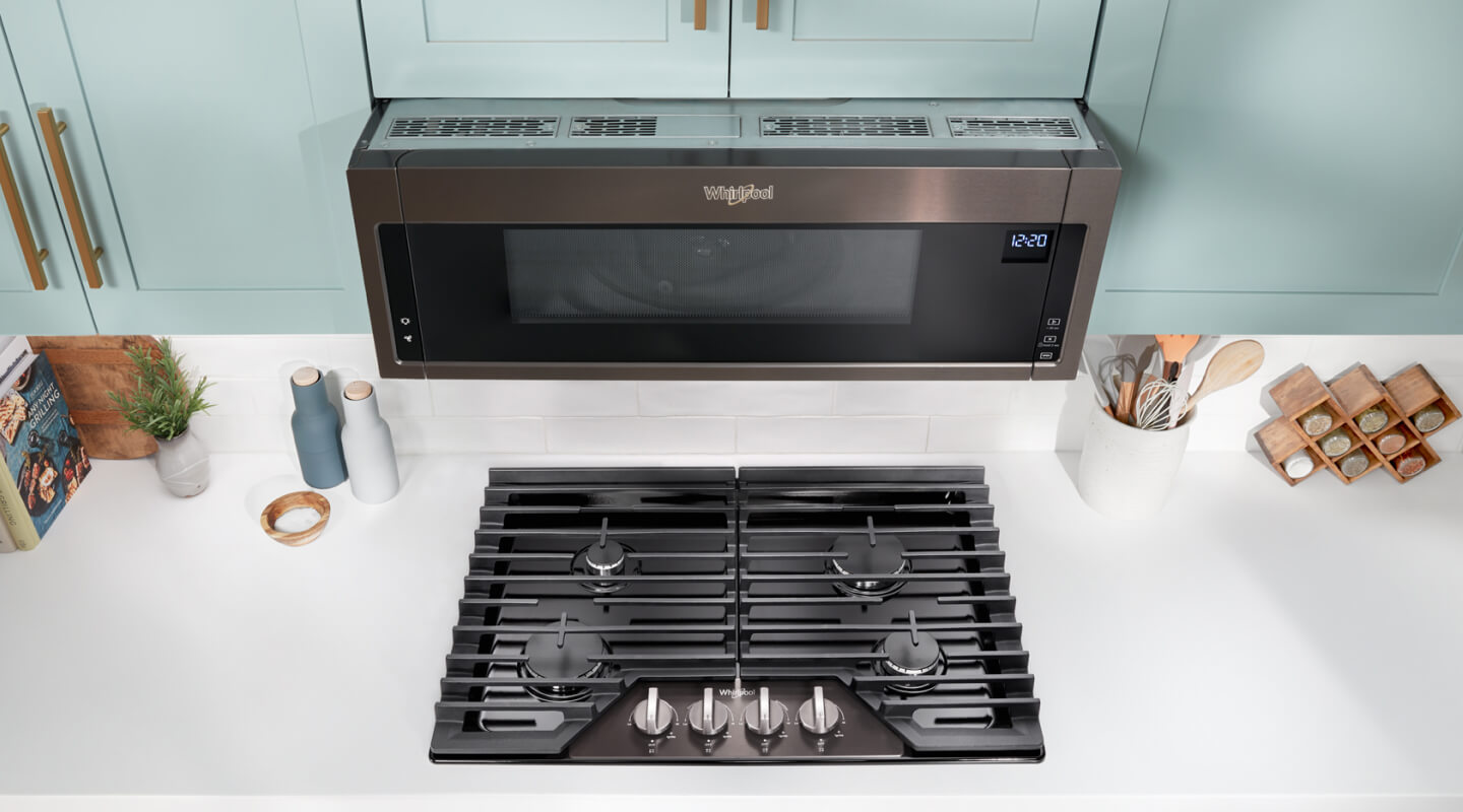 A Whirlpool® Over-the-Range Microwave above a gas cooktop