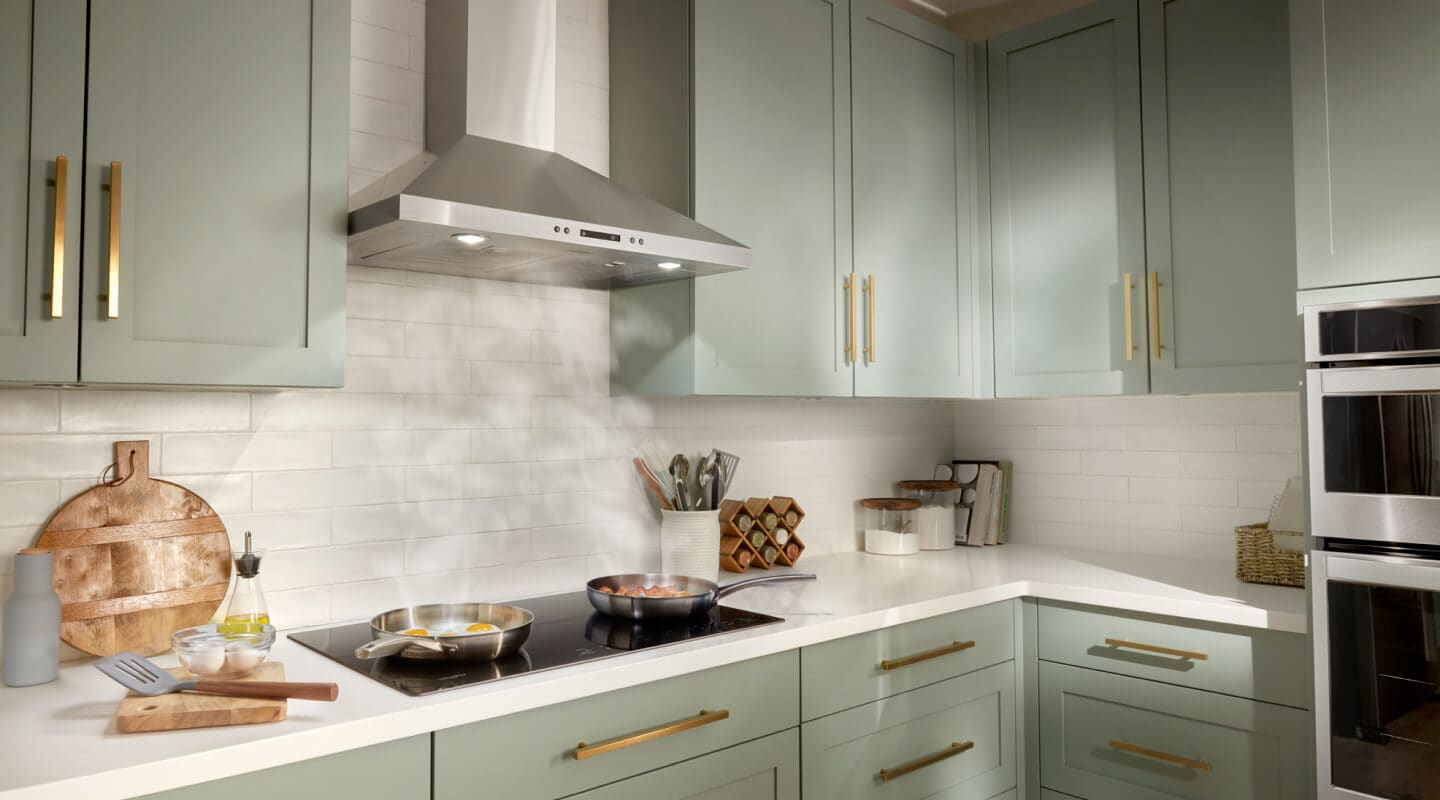 Steam from two pans rising underneath a canopy range hood Steam from two pans rising underneath a canopy range hood