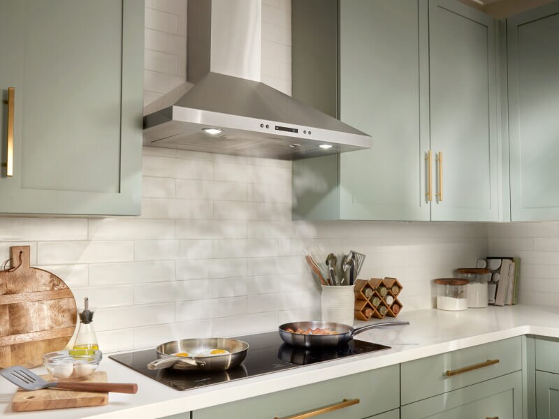 Steam from two pans rising underneath a canopy range hood Steam from two pans rising underneath a canopy range hood