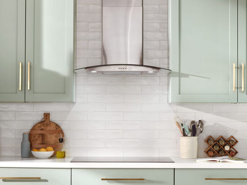 Range hood installed over an electric cooktop in a rustic kitchen Range hood installed over an electric cooktop in a rustic kitchen