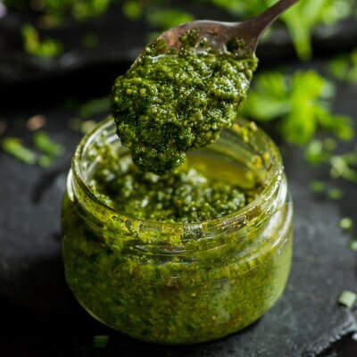 Pesto in a jar with a spoon in it
