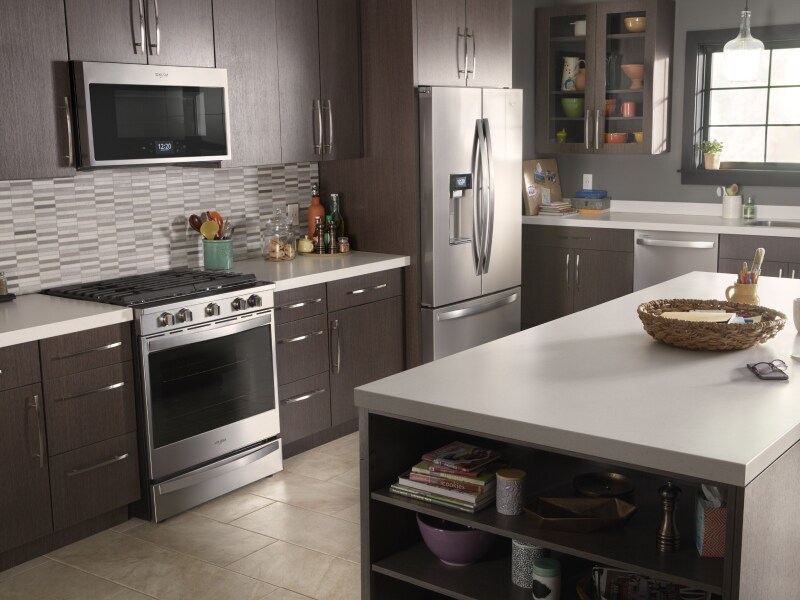 A Whirlpool® oven, over-the-range microwave, refrigerator and dishwasher in a modern kitchen.