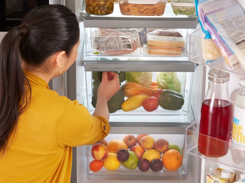 A person getting food out of their fridge A person getting food out of their fridge