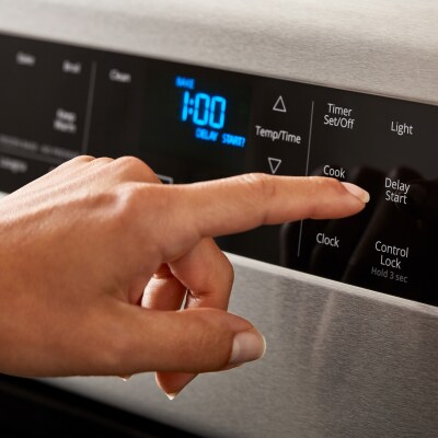 Person selecting a cook setting on a Whirlpool® Range