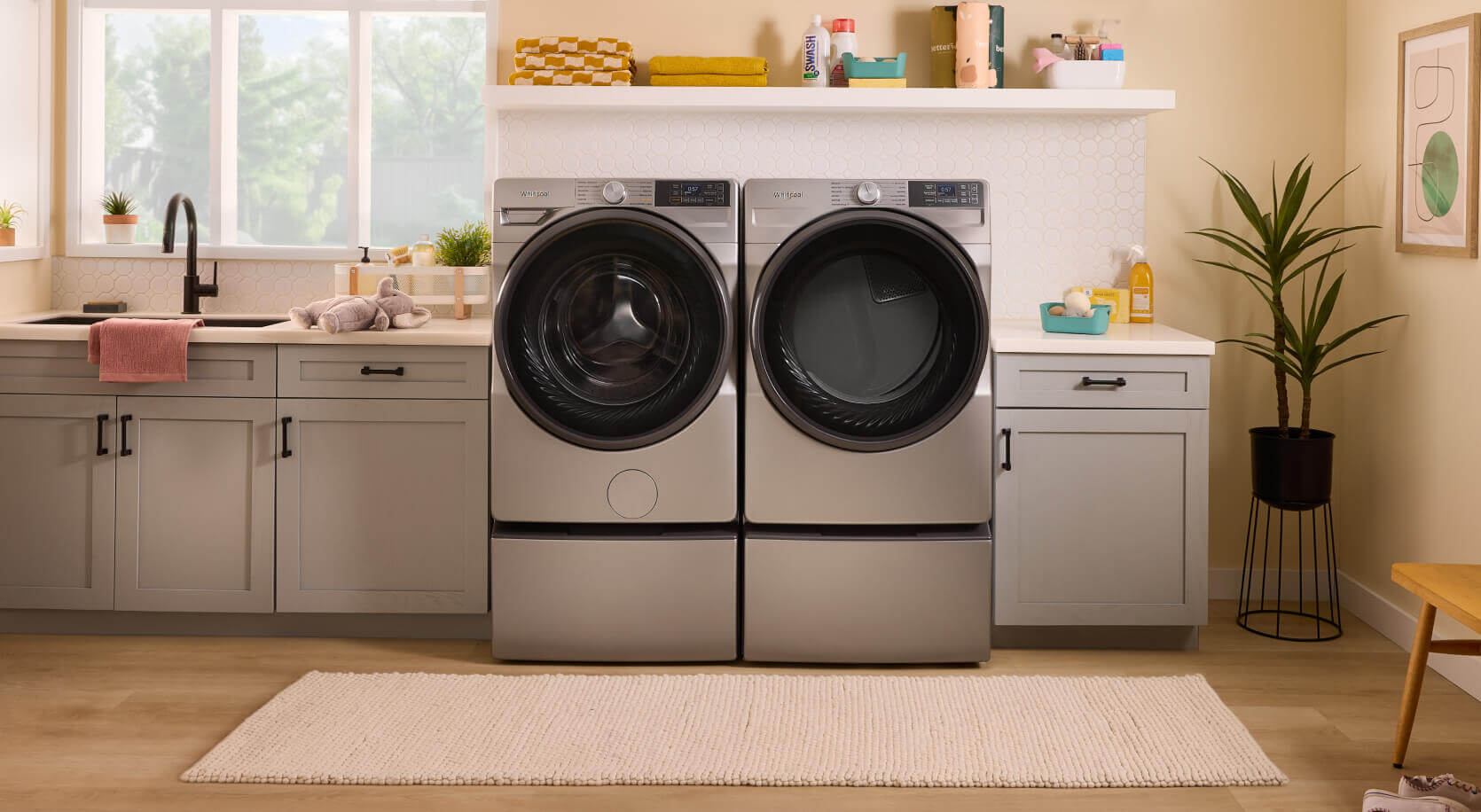 Silver Whirlpool® Front Load Washer and Dryer Pair in gray-blue cabinetry