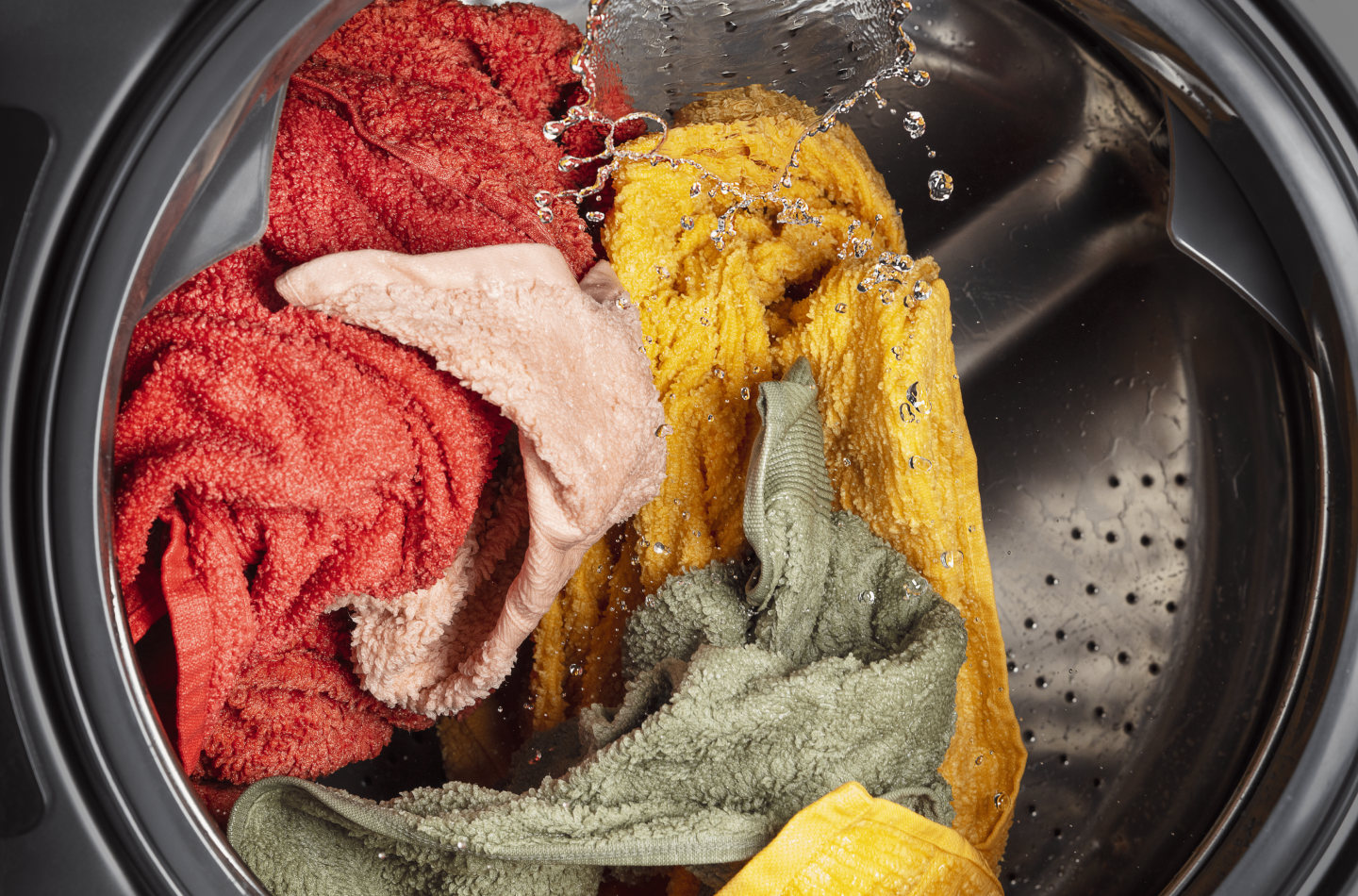 The inside of a washer with a load of laundry in the middle of a wash cycle The inside of a washer with a load of laundry in the middle of a wash cycle