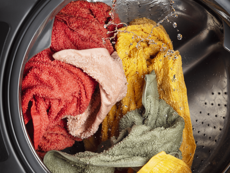 The inside of a washer with a load of laundry in the middle of a wash cycle The inside of a washer with a load of laundry in the middle of a wash cycle
