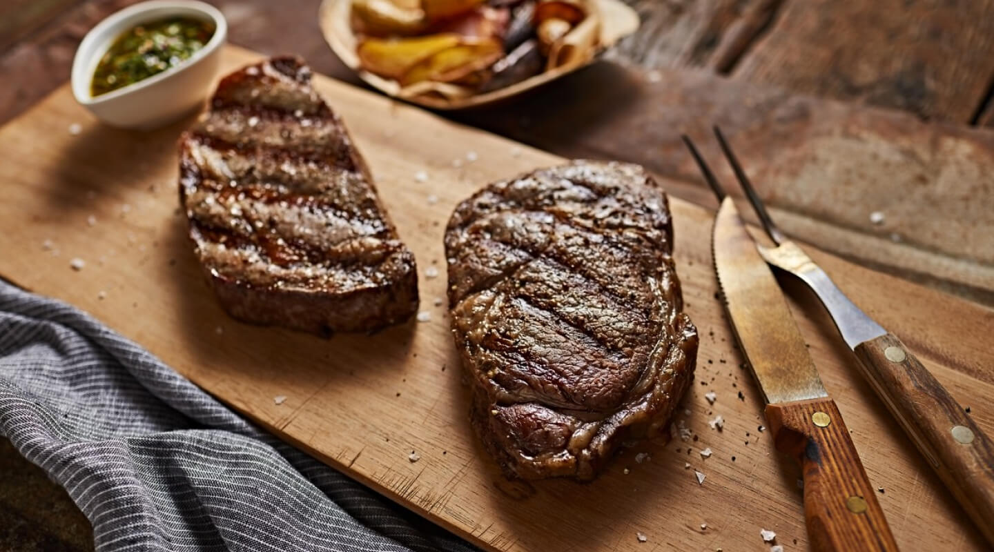 Two steaks on a cutting board Two steaks on a cutting board