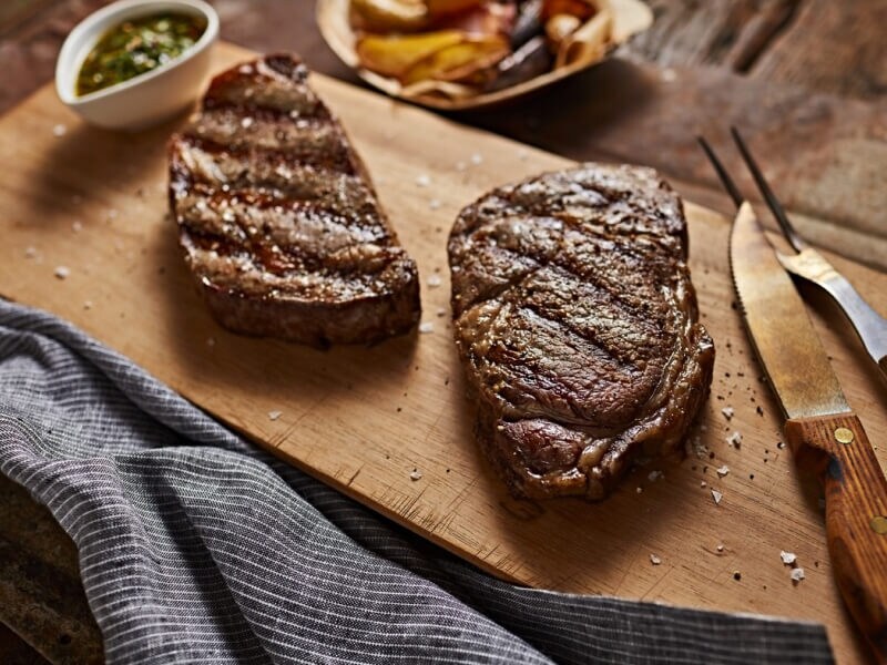 Two steaks on a cutting board Two steaks on a cutting board