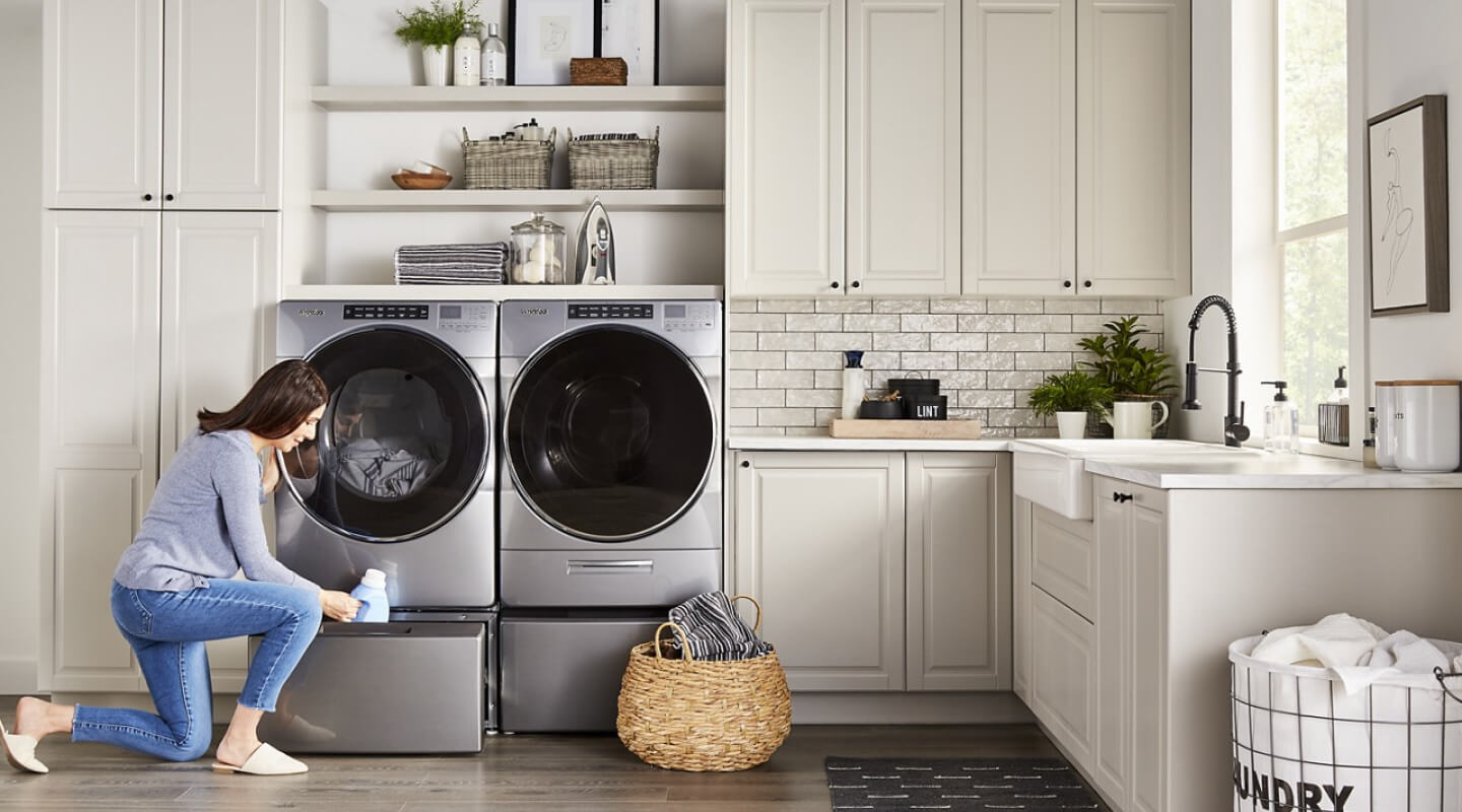 Person putting fabric softener into a washer pedestal Person putting fabric softener into a washer pedestal
