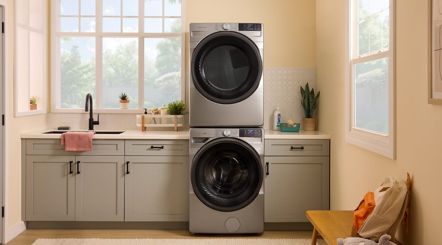 Stainless steel front load washer and dryer in a laundry room with gray cabinetry Stainless steel front load washer and dryer in a laundry room with gray cabinetry