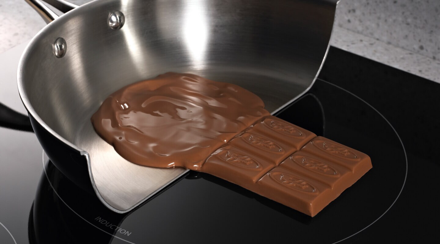Chocolate melting in a pan and solid on the induction cooktop surface Chocolate melting in a pan and solid on the induction cooktop surface
