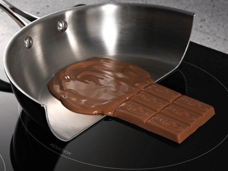 Chocolate melting in a pan and solid on the induction cooktop surface Chocolate melting in a pan and solid on the induction cooktop surface