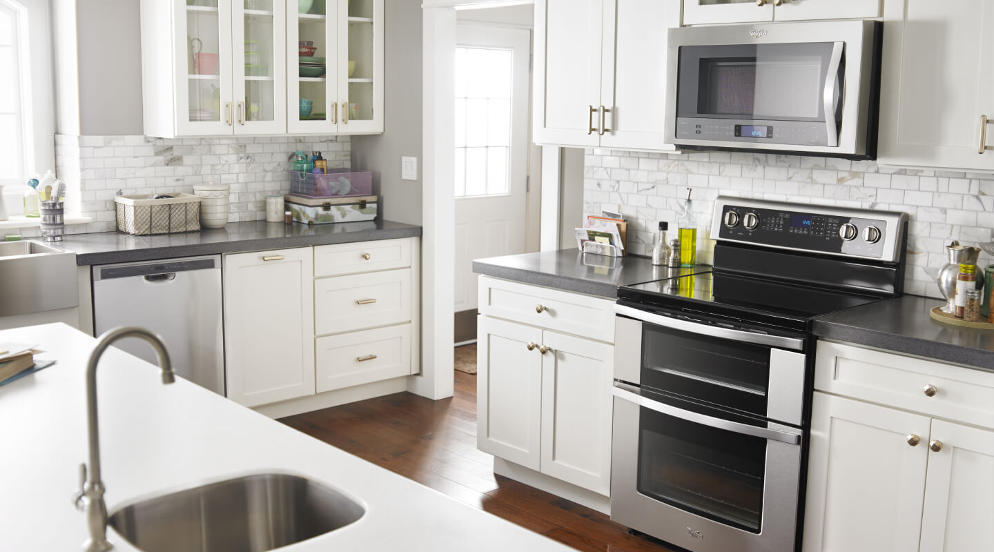 A bright kitchen with white cabinets and a Whirlpool® Double Oven Range
