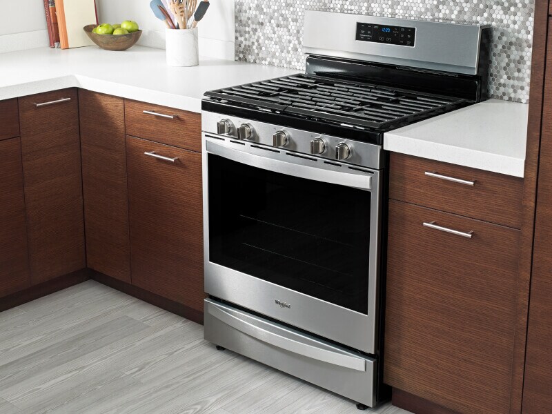 Freestanding gas range in a kitchen with wood cabinets