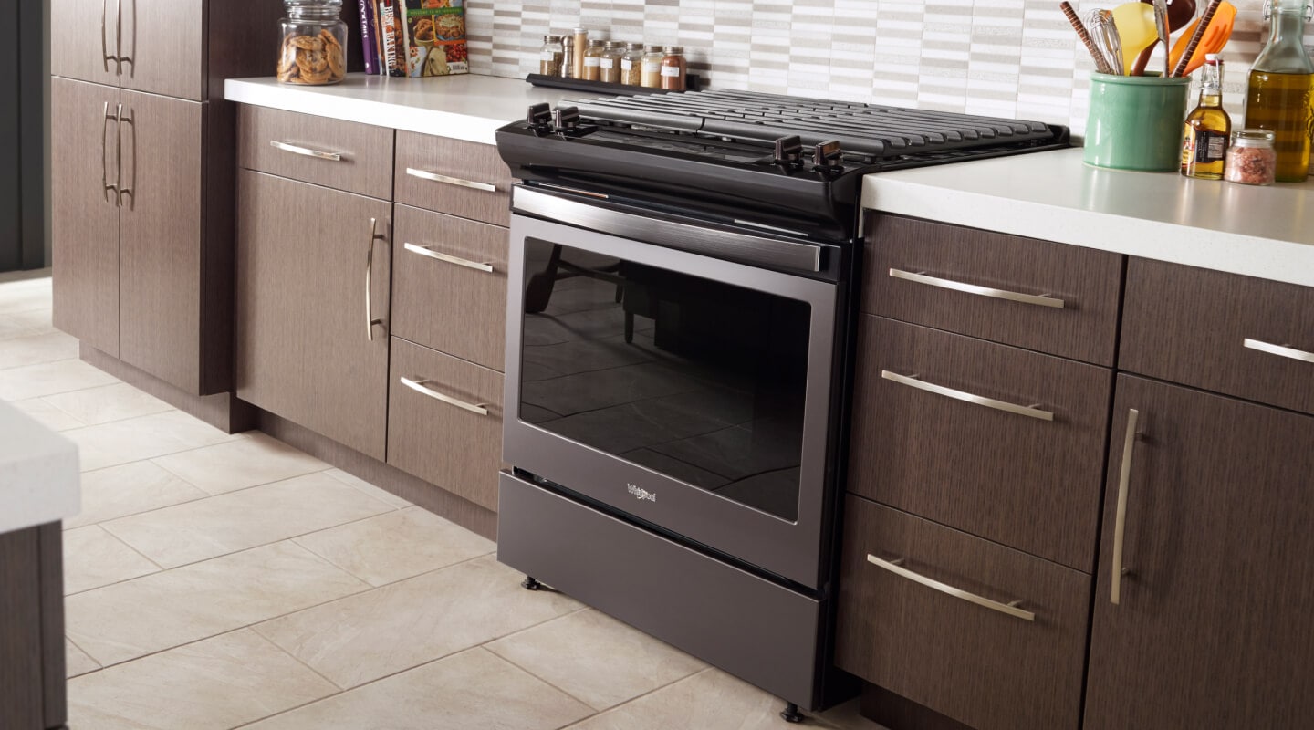 Slide-in black electric range in a big kitchen