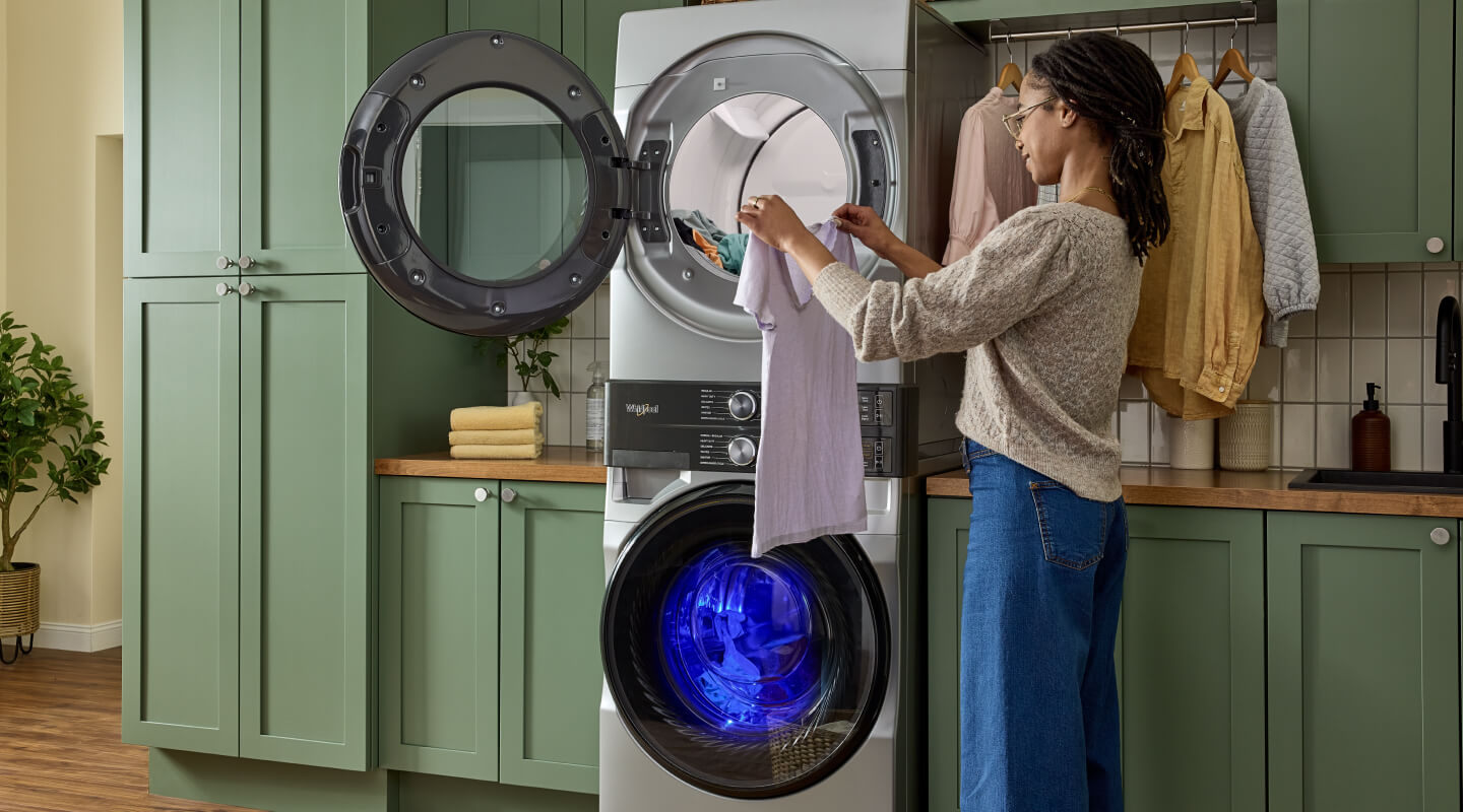 Person doing laundry in front of a stackable laundry set