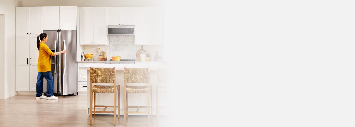 Person opening a side-by-side refrigerator