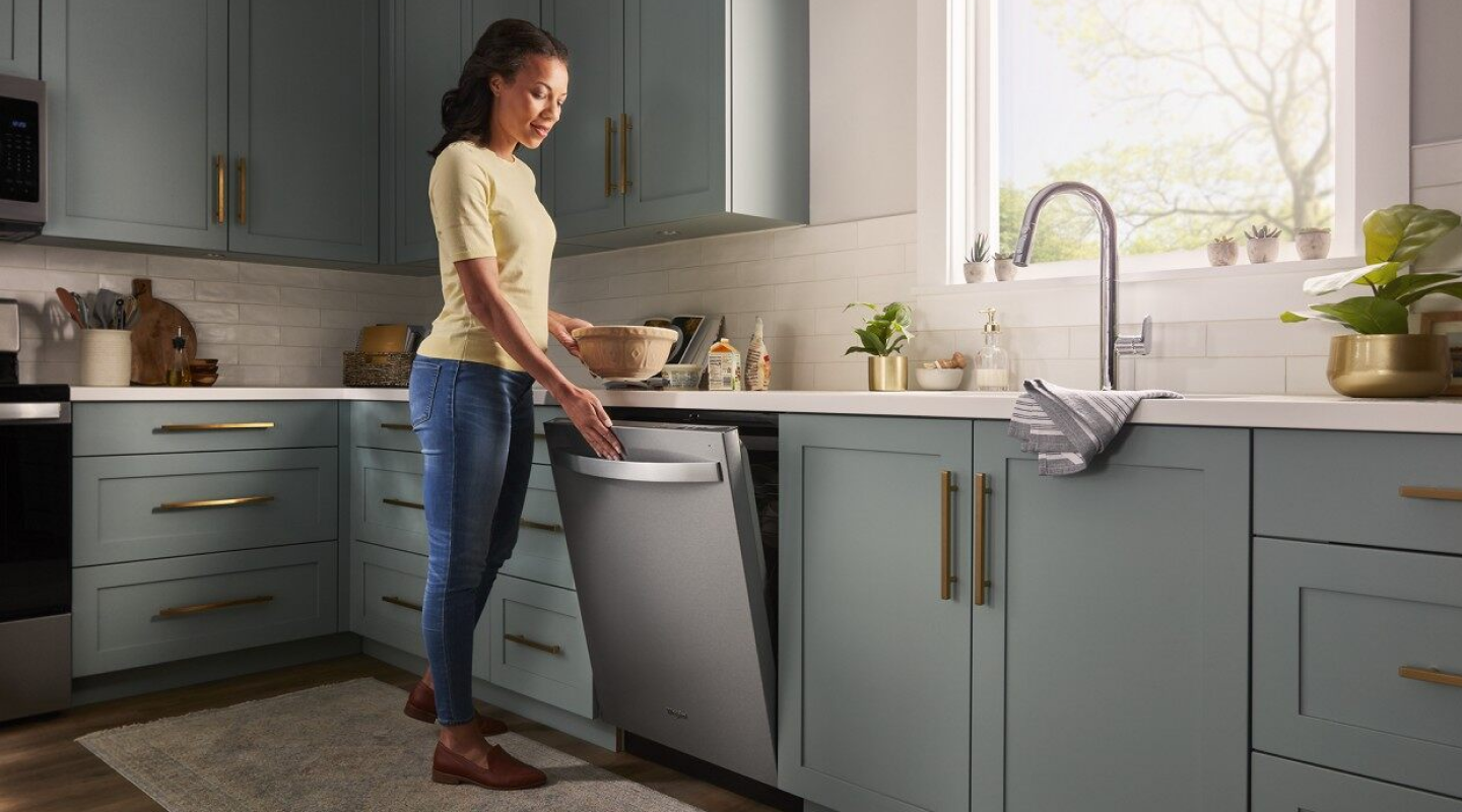 Woman opening a Whirlpool® top control dishwasher Woman opening a Whirlpool® top control dishwasher