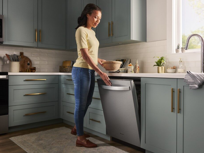 Woman opening a Whirlpool® top control dishwasher