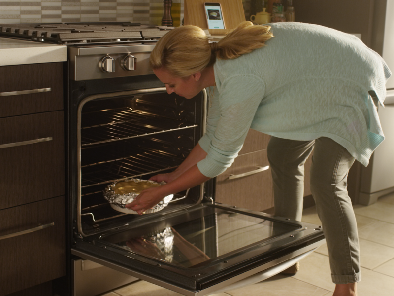 Person placing food in an oven Person placing food in an oven