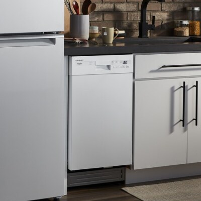 A white Whirlpool® Dishwasher in a kitchen with a white refrigerator