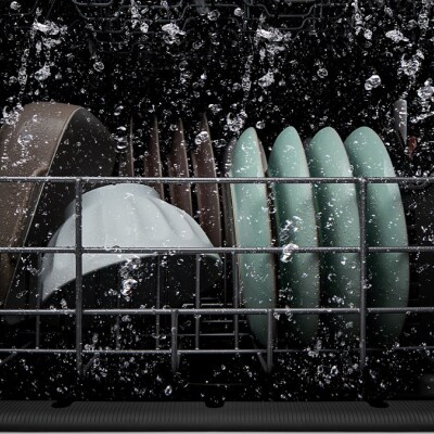 Dishes getting washed inside a dishwasher