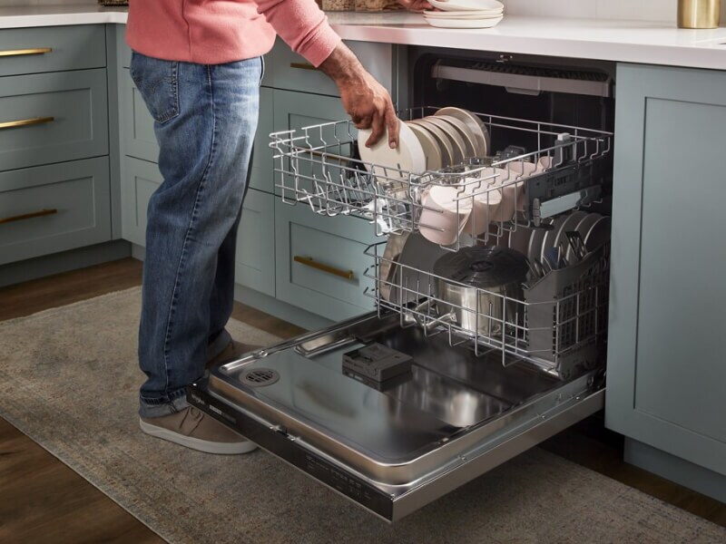 A person loading a dishwasher A person loading a dishwasher