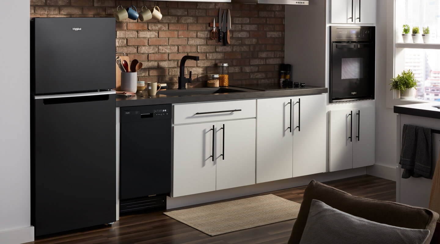 The interior of a kitchen with a top freezer in it from Whirlpool brand