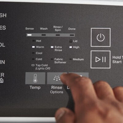 Close up of a person selecting a washer setting on the control panel of a Whirlpool® Washer