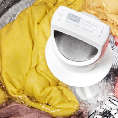 Interior of a Whirlpool® Washer with an agitator washing yellow, gray and white garments
