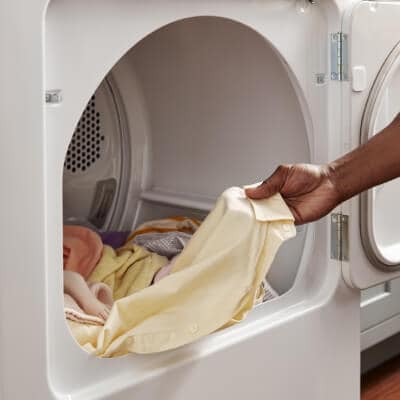 Close up of a person unloading a Whirlpool® Dryer