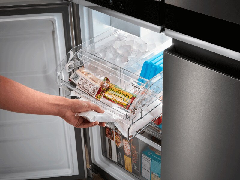 Person removing an item from a freezer Person removing an item from a freezer