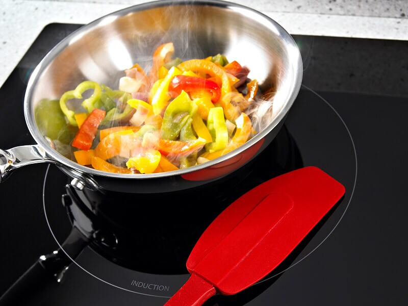 Bell peppers cooking in a pan on an electric cooktop Bell peppers cooking in a pan on an electric cooktop