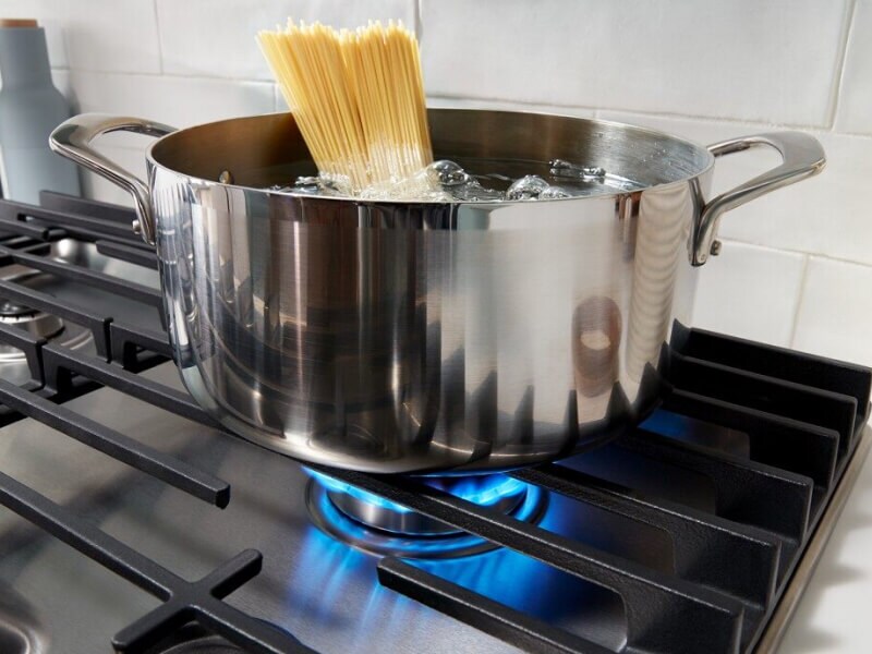 Pasta cooking in a pot on a gas cooktop Pasta cooking in a pot on a gas cooktop