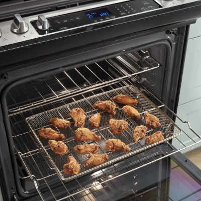 Chicken wings cooking in an air fry oven