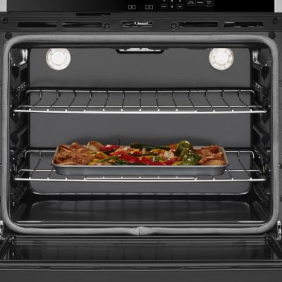 Chicken and vegetables roasting in a conventional oven