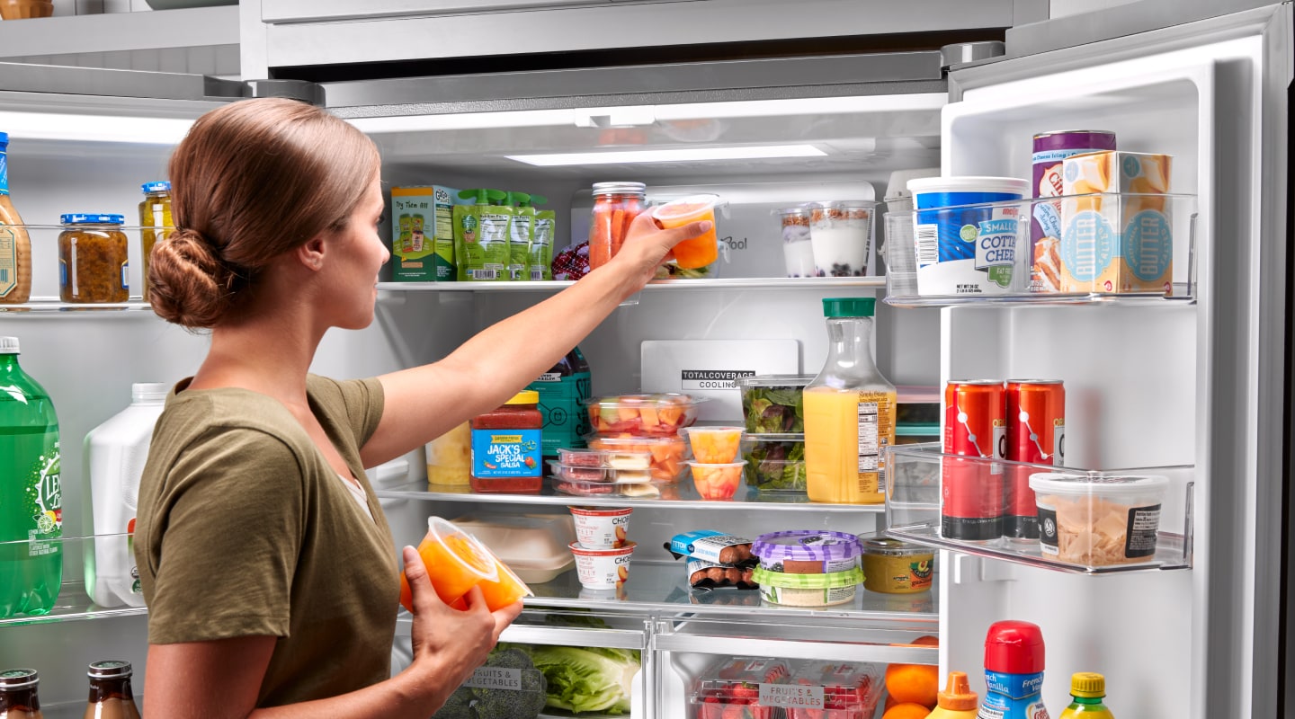 Person placing items on top shelf of Whirlpool® refrigerator Person placing items on top shelf of Whirlpool® refrigerator