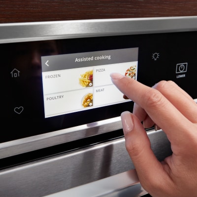 A person making a selection on a Whirlpool® smart wall oven