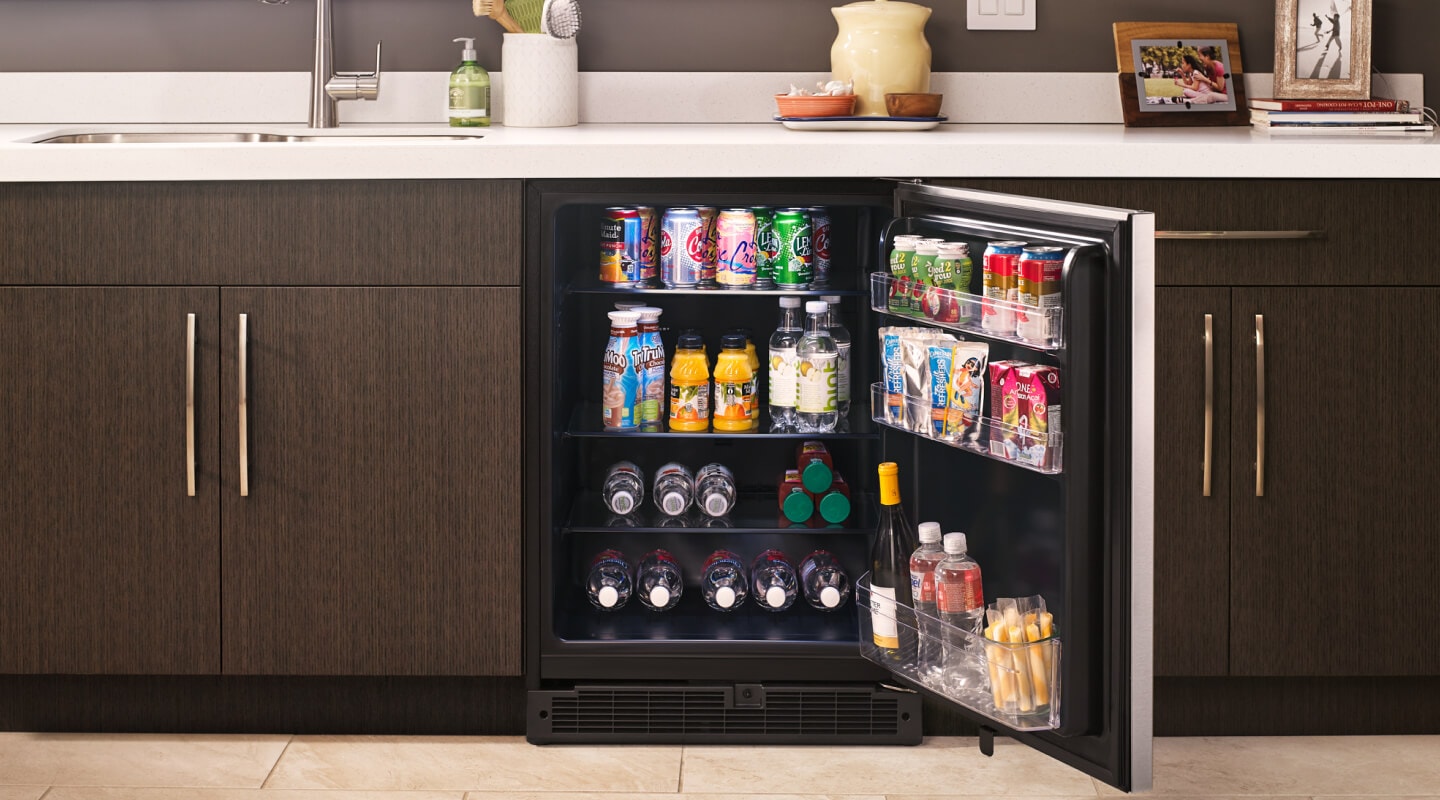 Fully stocked open undercounter refrigerator in a kitchen  Fully stocked open undercounter refrigerator in a kitchen