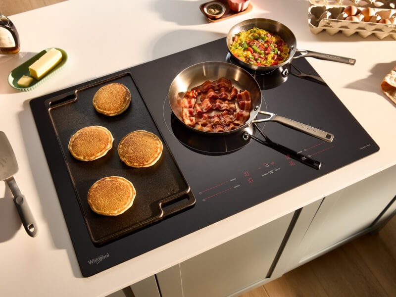 A griddle and a saucepan on an electric cooktop