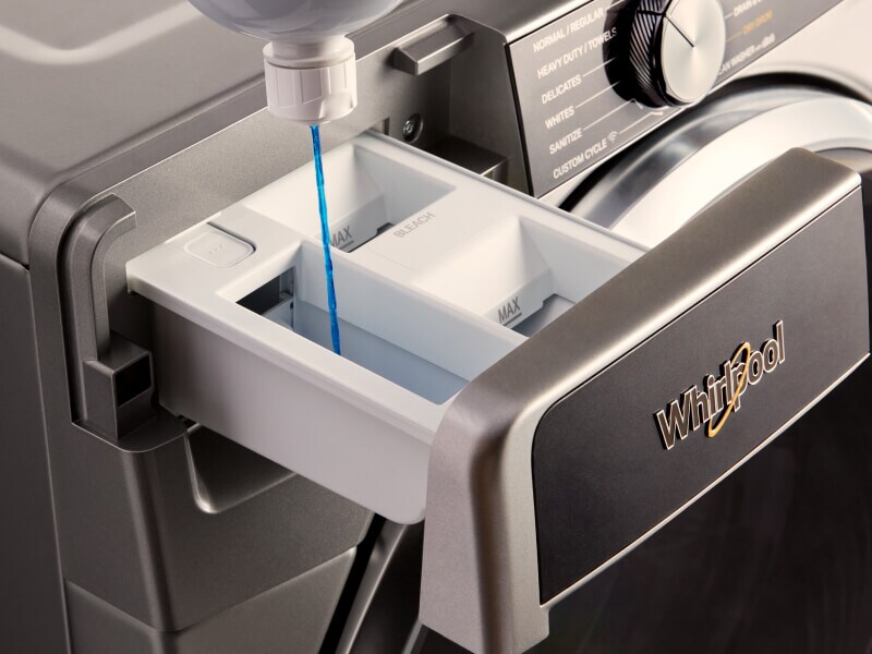 Person filling detergent compartment with laundry detergent