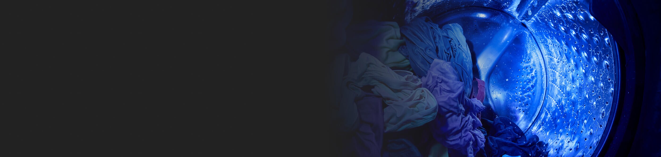 Blue UV light shining on clothes inside a wash basket with laundry