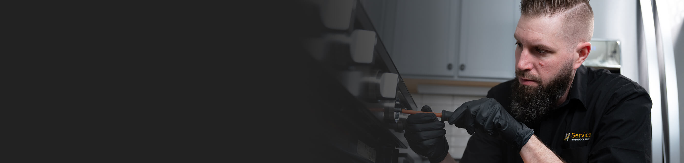 A technician working on a kitchen stove