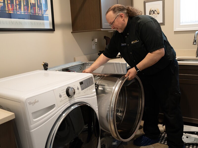 A technician working on a dryer A technician working on a dryer