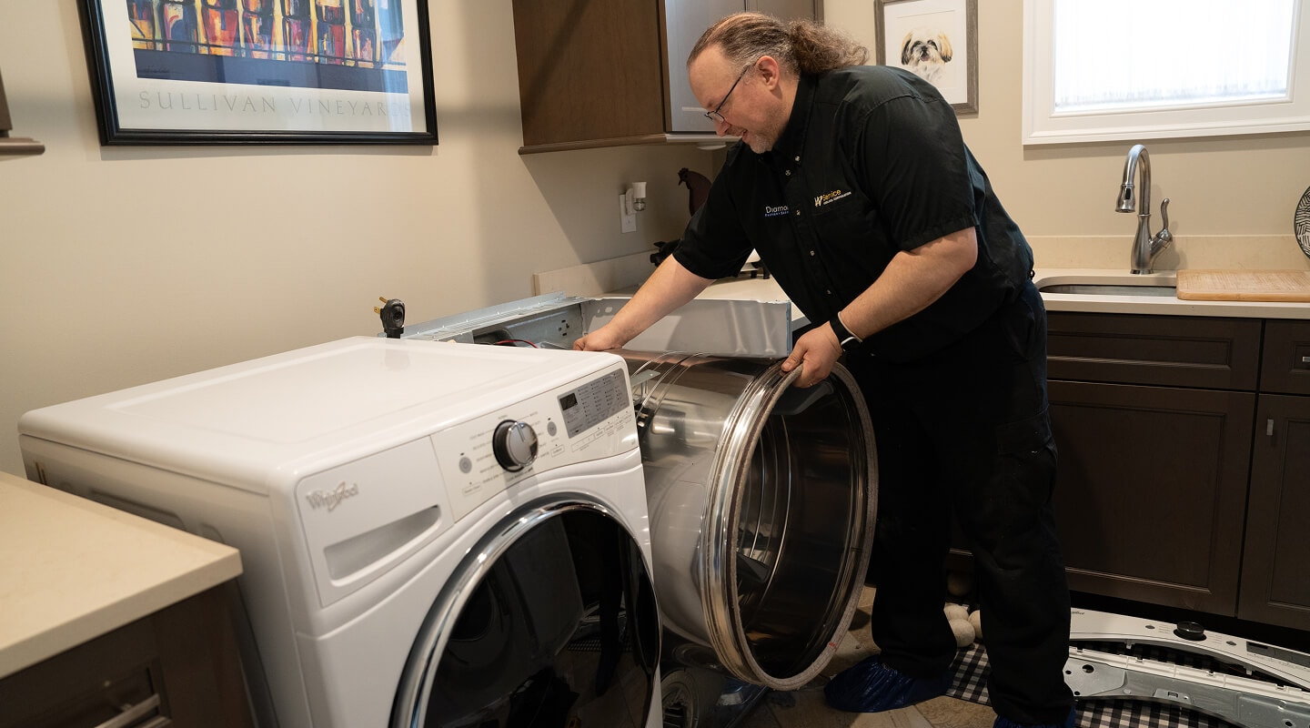 A technician working on a dryer A technician working on a dryer