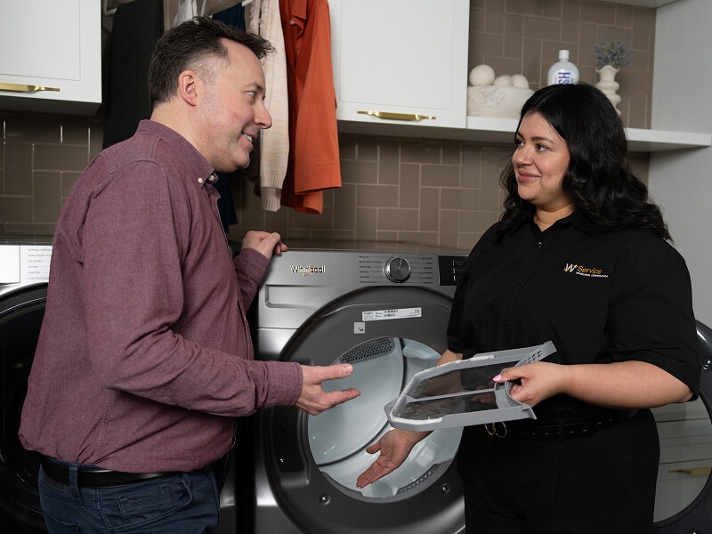 A technician helping a man with his dryer A technician helping a man with his dryer